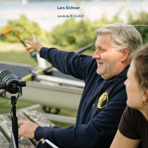 Eine männliche Person gestikuliert und erklärt im Gespräch im Freien.