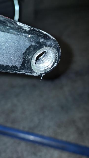 Manivelle d'un pédalier de vélo avec le filetage de la pédale bouffé sur la moitié de sa longueur