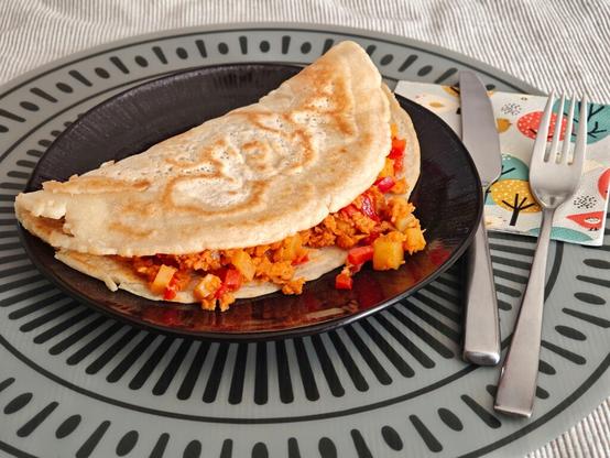 zur Hälfte zugeklappter Pfannkuchen mit beschriebener Füllung