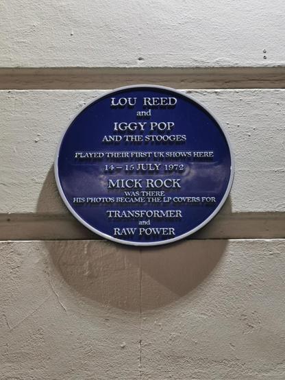 Blue plaque on a white background. The sign states that both LOU Reed and Iggy & Stooges played their first UK shows at this venue 14th and 15th July 1972. Photos from the show were used for the covers of Transformer and Raw Power.