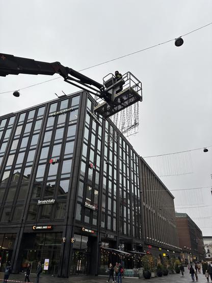 Workers putting up Christmas lights - jouluvalojen nosto Helsingin keskuskadulla