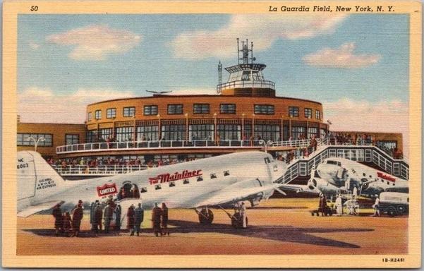 This striking postcard captures LaGuardia Field in New York at the height of the 1940s aviation boom, a period when air travel symbolized speed, luxury, and modernity. In the foreground, sleek United Air Lines “Mainliners”—most likely Douglas DC-3s—sit proudly on the tarmac, their polished silver fuselages gleaming under a bright sky. Passengers in heavy coats and hats gather below, preparing to board, while ground crew and attendants move with purpose, embodying the efficiency and excitement of early commercial flight.

Behind them rises the airport’s iconic circular terminal and control tower—an architectural statement of progress and optimism. The curved façade, observation deck, and glass-lined control room showcase the Art Deco and Streamline Moderne influences that defined prewar transportation design. Crowds of spectators fill the balconies, watching the planes come and go, a reminder that in this era, flying was both a spectacle and a privilege.

LaGuardia Field, which opened in 1939, was one of the most advanced airports in the world, offering passengers direct access from the city to destinations across the nation. This postcard not only celebrates that achievement but also evokes a distinct moment in American history—when the thrill of flight promised a boundless future and New York stood proudly as the gateway to the skies.
