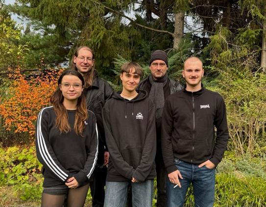 5 Menschen stehen im Garten und lächeln in die Kamera