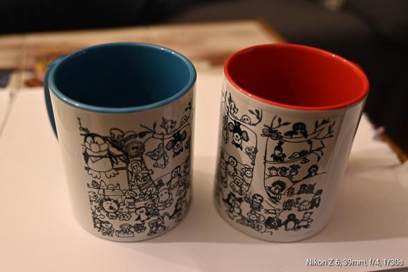 Zwei Kaffeebecher, der linke innen blau, der rechte innen rot, mit den Zeichnungen der Plüschies der twitter Plüschbubble, die durch den Verkauf leider auseinandergerissen wurden.
Die Zeichnung stammt von Flori Penguin.