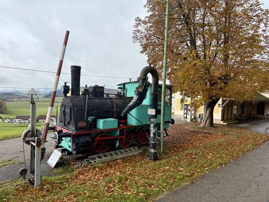 Als Denkmal aufgestellte Lok „Aigen“ neben dem Bahnsteig in Rohrbach-Berg. Daneben wurden eine Schranke und ein Wasserkran aufgestellt.