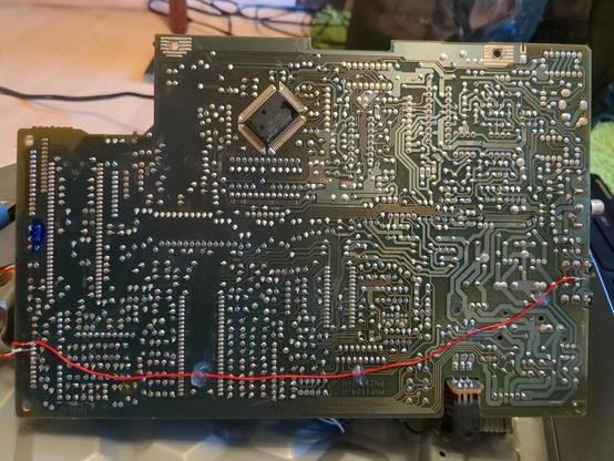 Underside of the CD player's main PCB. A newly installed bodge wire, carrying the IR sensor's signal across the PCB. Theoretically it should have been possible to place a couple of jumper wires in the right places, but at least one of them is inconveniently located under a big IC. The others aren't very easy to identify, since my service manual appears to be for a model with slightly different PCB revision.