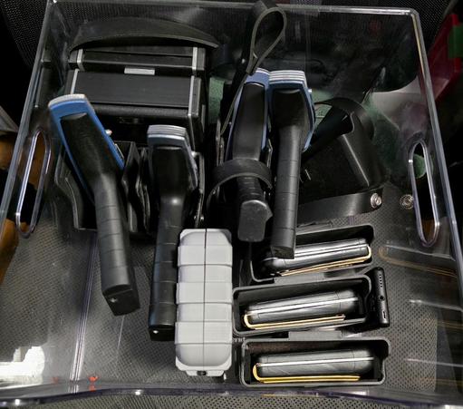 A bin full of Star Trek Strange New worlds props. Four phasers, two tricorders, and four  communicators (One is in a grey case)