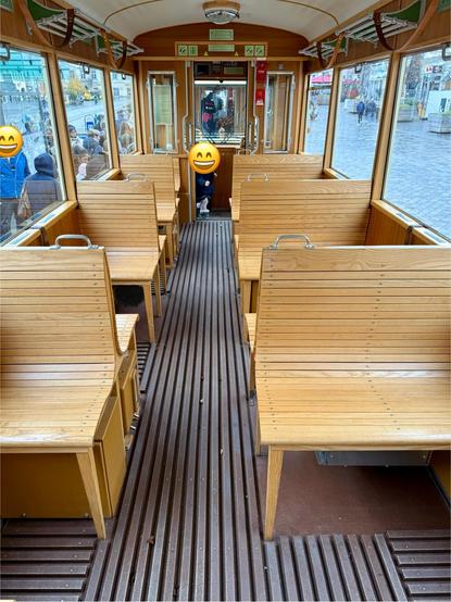 Im Inneren eines der historischen Triebwagen. Holzbänke stehen konform zur Fensterteilung.
