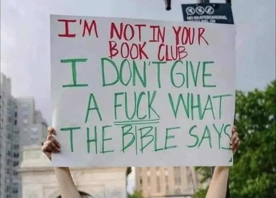 someone holding up sign that says 'i'm not in your book club - i don't give a f*ck what the bible says