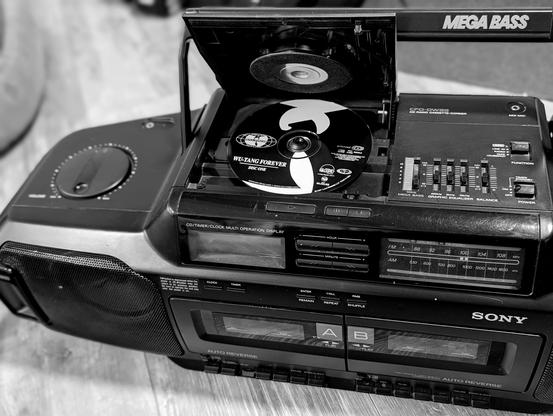 Black and white photo of a Sony Mega Bass boom box with the CD lid open and Wu-Tang Forever Disc One loaded.