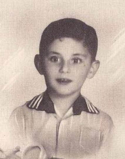 Vintage black and white portrait of a young boy, looking directly at the camera.