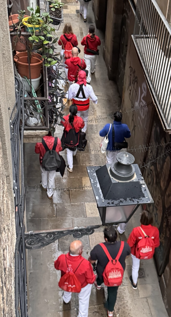 A group playing musical instruments walks down a narrow street in Ciutat Vella at 8am on a Sunday