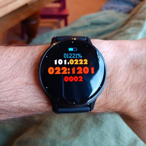 A Garmin Venu 3 watch with a watch face that shows the current time encoded in ternary, with colourful digits:

022:1201 = 08:46