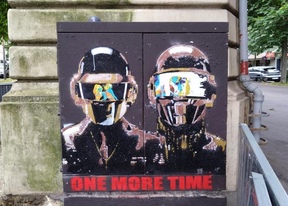 Daft punk street art on an electrical cabinet. Visors on the helmets contain a collage of scenes from One More Time.