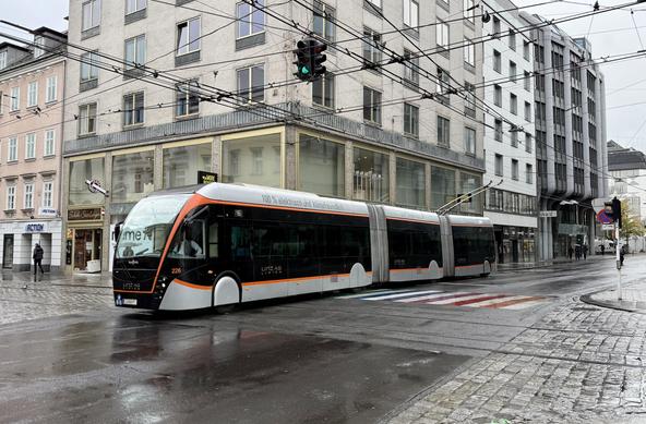 Ein O-Bus fährt über die Kreuzung einige Meter weiter, mit gehobenem Stromabnehmer.
