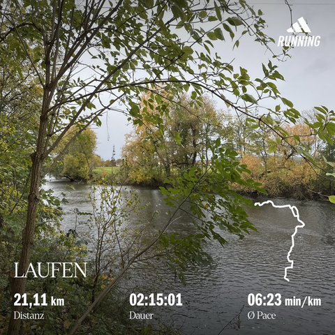 Blick über einen Fluss (Saale), eingerahmt von herbstlichen Bäumen und Sträuchern und am Horizont ist eine Siedlung (Schellsitz) mit einer Kirche erkennbar