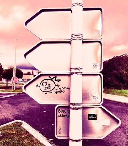 Des graffitis sur le thème de l'auto-stop sur un panneau de signalisation