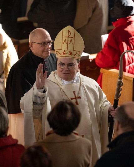 Bischof Dr. Bertram Meier segnet beim Einzug zum Gottesdienst Menschen.