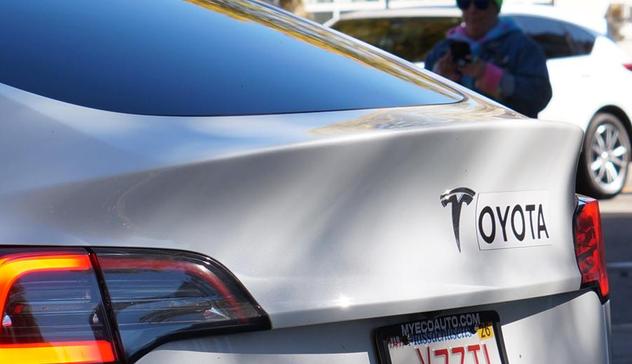 Tesla with 'OYOTA' next to the Tesla T on the trunk lid
