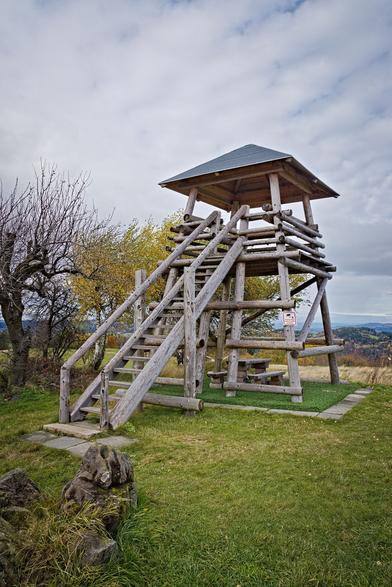 Dřevěná rozhledna Bůřov, hned za ní stromy.