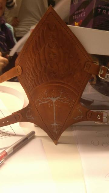 Poor quality pic of a leather Boromir bracer, all in medium brown except the Gondor tree and side decos, that are a dirty white. Embossed leather with dark brown thread and silver buckles