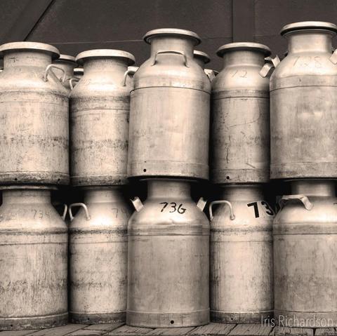 Old milk cans sepia tone photograph