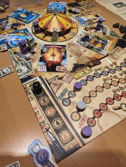 Spielboard mit 3d Karussell zum drehen, daum verschiedene Attraktionskarten Stapel, darunter leiste thrill, awe und joy