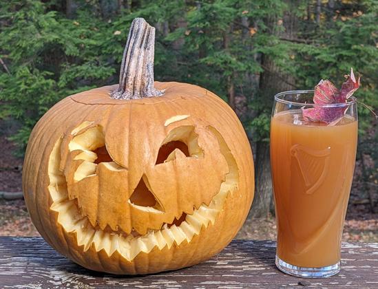 Carved pumpkin and cider.