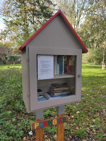 Alt1: Taupe kastje met rood dak op twee pilaren. Aan de pilaren is een balkje bevestigd met daarop 'Parkbieb' in geel-blauw-rood-groene letters. 
Op de ruit een infoblad van de beheerders: over wat de parkbieb is, hoe het werkt en waar men meer informatie kan vinden.
