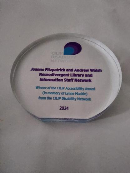 A glass award engraved with NLISN details