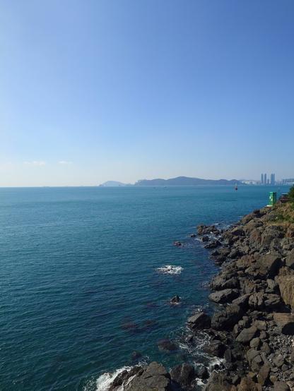 The rocky coast view from the Haewol sky walk. Haeundae skyline is visible from afar