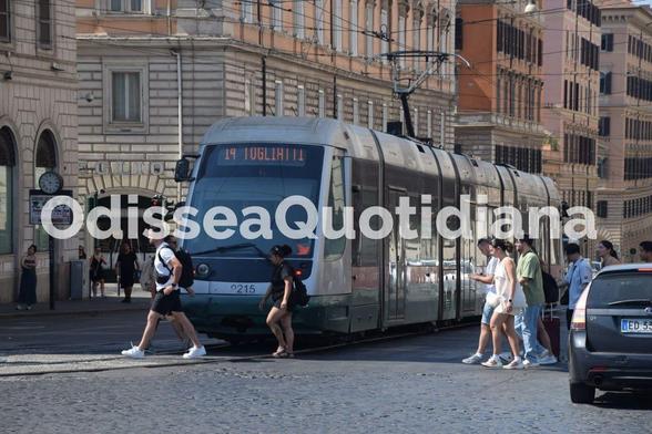 Tram di Roma in transito a un incrocio con semaforo, simbolo della necessità di precedenza semaforica