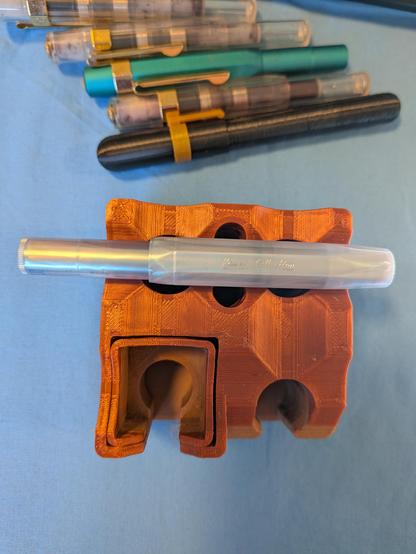 A Kaweco Sport, with a pearl like sheen is sitting on a stand. More Sport pens and a 3d printed pen can also be seen to the top of the picture.