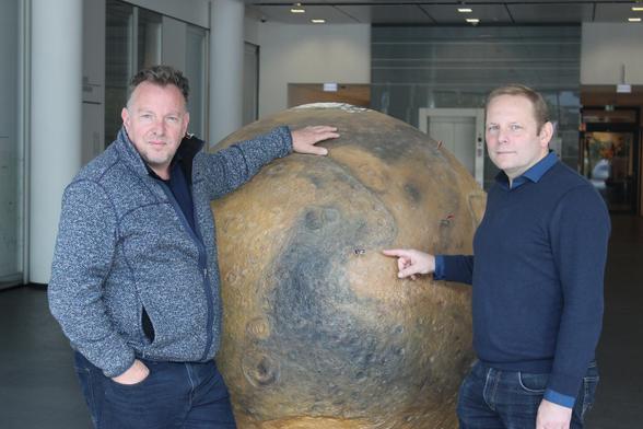 Andreas Pack (left) and Christian Schröder (right) standing infront of a large model of Mars.