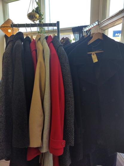 a rack of red, brown, black and blue wool coats