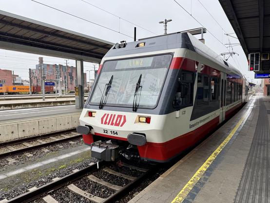 Triebwagen der Linzer Lokalbahn bei der Einfahrt am Bahnsteig in Linz Hbf.