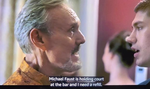 Anthony Head is pictured talking to Archie Renaux in Upgraded. He says "Michael Faust is holding court at the bar and I need a refill."