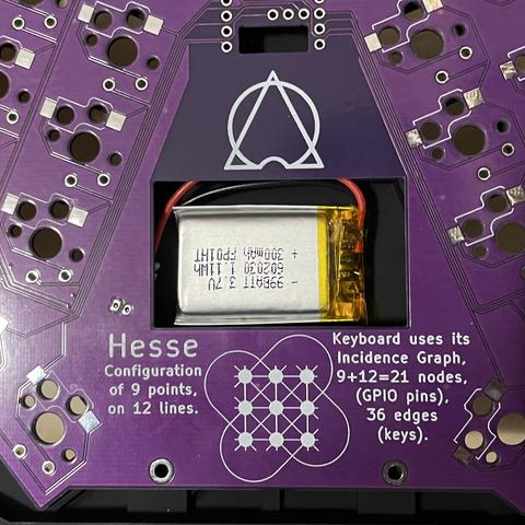 Photo of underside of Gamma Omega Hesse keyboard PCB (in purple) in the top case (black) with a small looking LP602030 LiPo battery in the cutout with plenty of room to spare.
