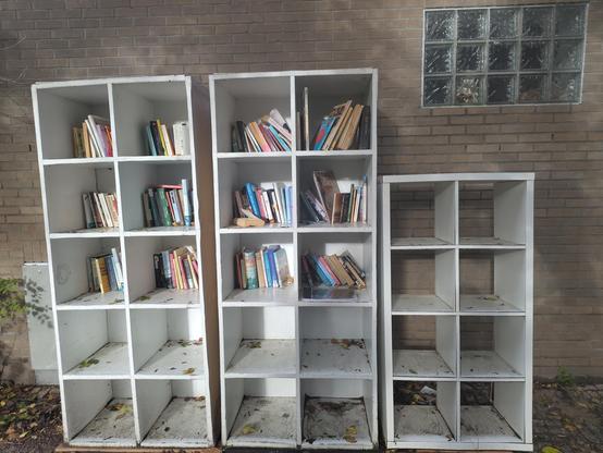 Large white bookcases (3) in front of a brick wall