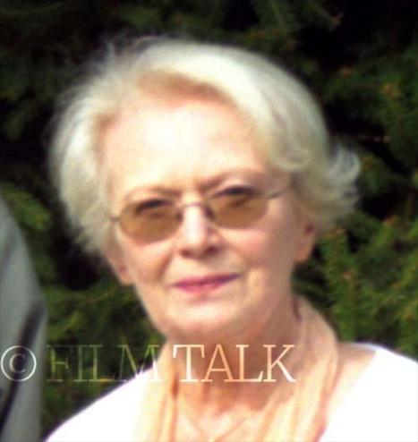 Ann Gillis as older person, grey haired and with glasses.