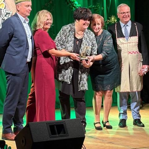 Ingrid Kühne nimmt ein goldenes Spinnrad von Jürgen B. Hausmann entgegen.