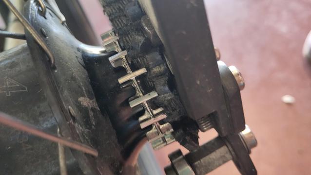 Gros plan sur le pignon de la roue arrière avec la courroie entortillée à côté