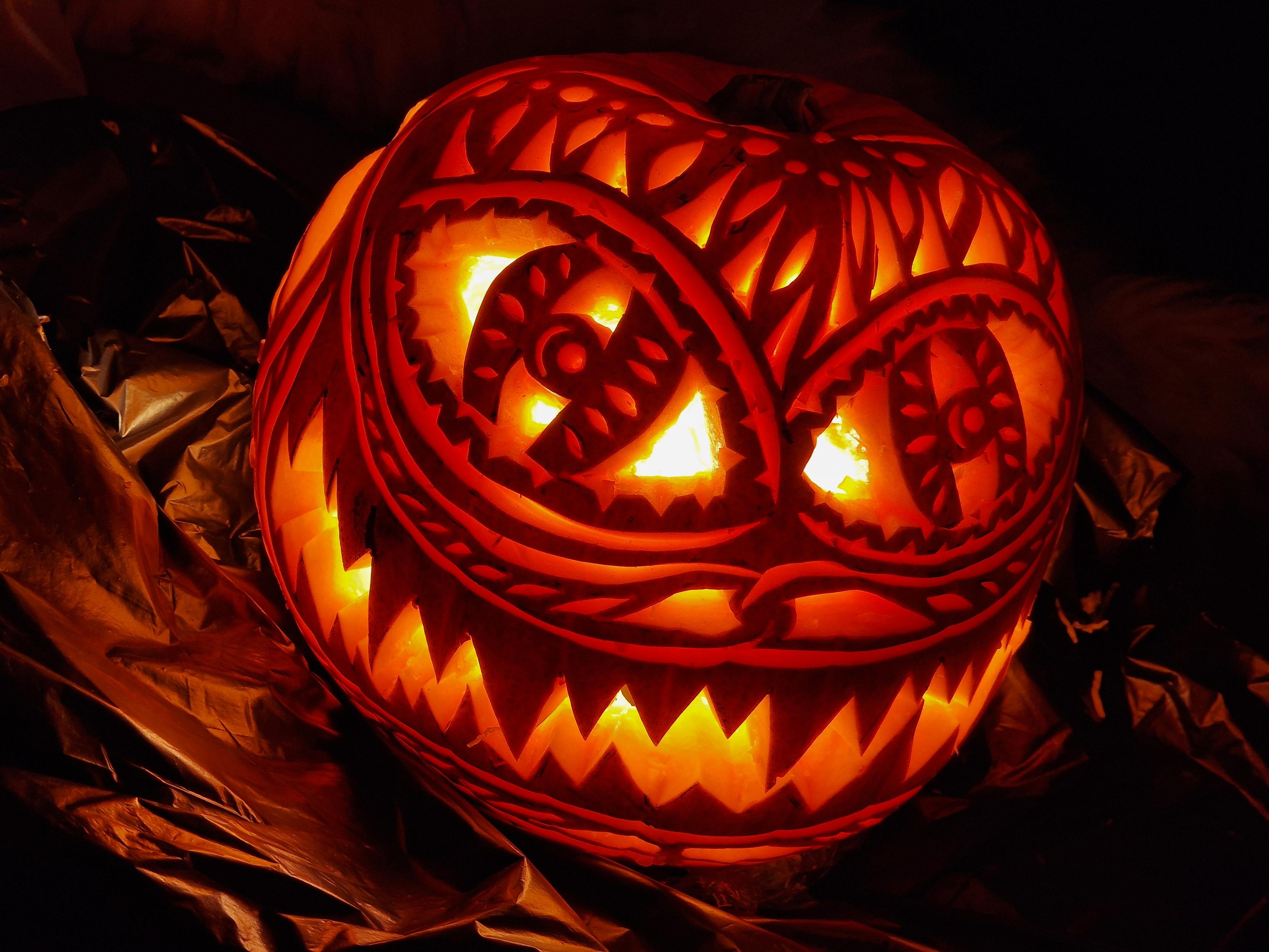 Ornately carved pumpkin with a big sharp toothed grin