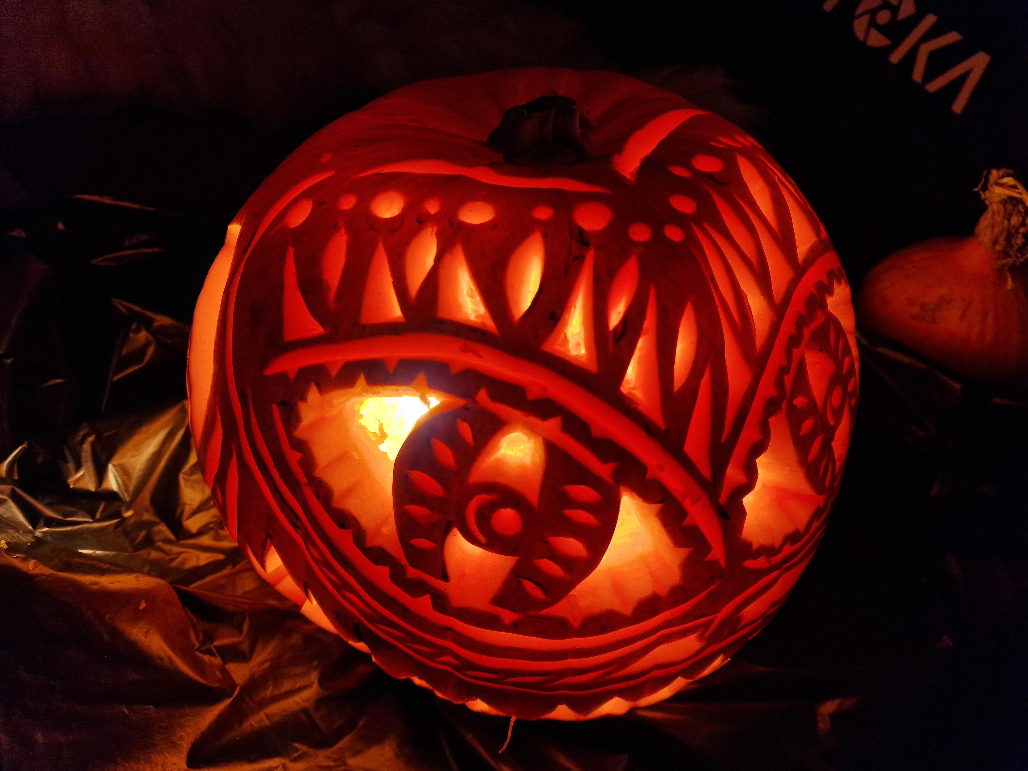 Ornately carved pumpkin with a big sharp toothed grin