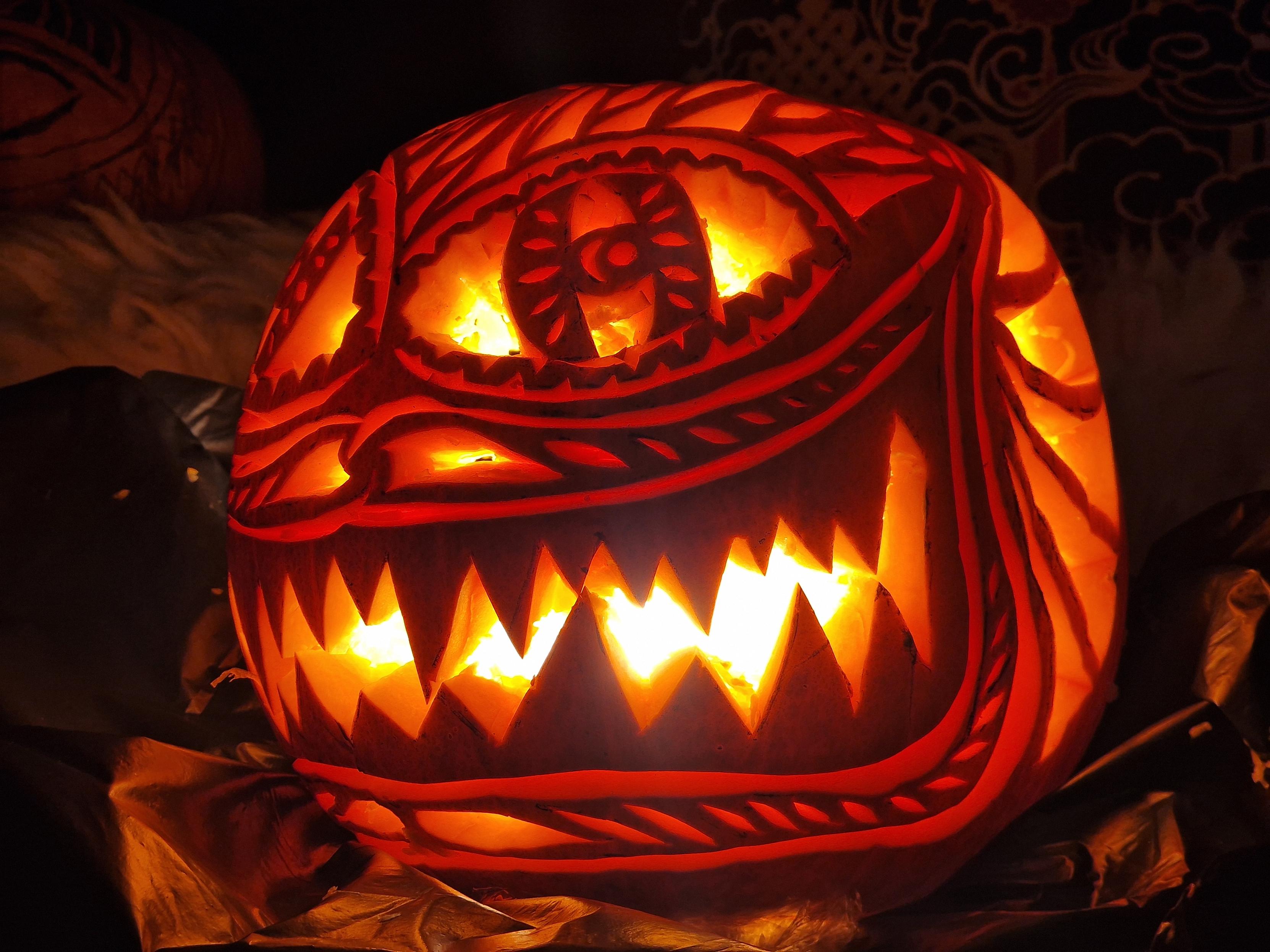 Ornately carved pumpkin with a big sharp toothed grin