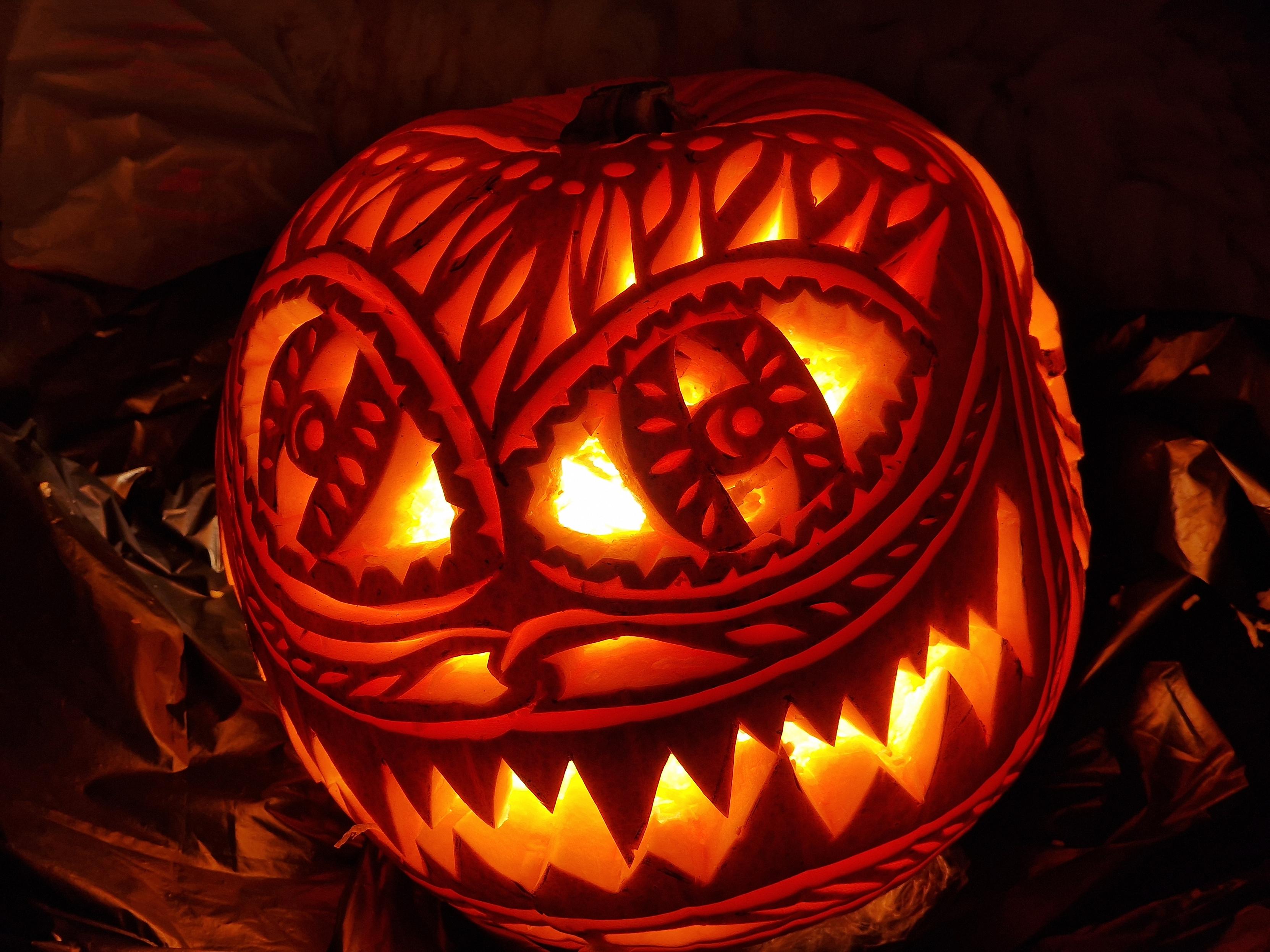 Ornately carved pumpkin with a big sharp toothed grin