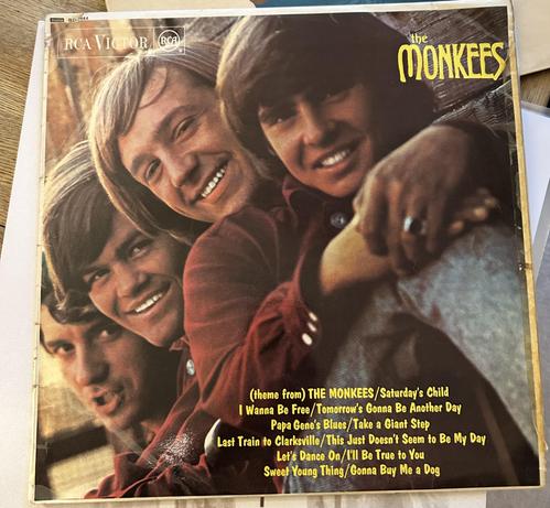 The Monkees band members smiling, with song titles listed on the album cover.