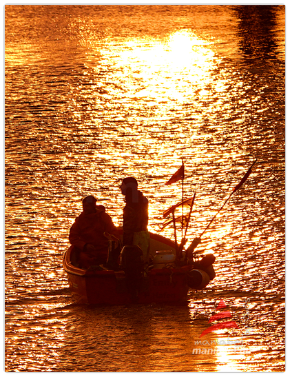 Kleines Fischerboot gleitet auf dem goldenen Sonnenstrahl...