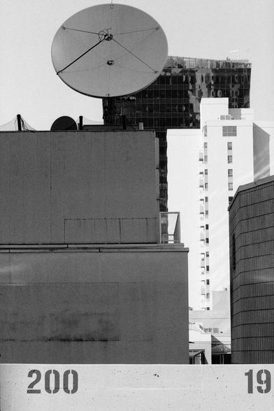 Downtown buildings loom as daylight reaches for street level.