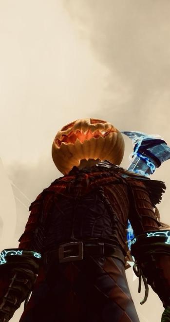 A character with a carved pumpkin for a head, dressed in dark, textured armor. The character holds a glowing blue weapon and is viewed from below against a cloudy sky.